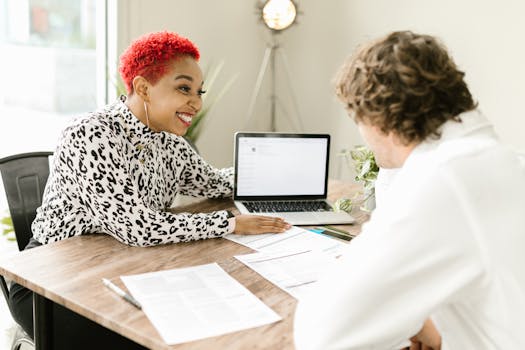 Smiling professionals discussing business documents at modern office table.