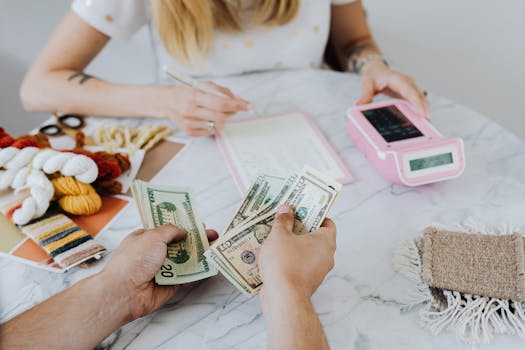 Two people handling cash and budgeting with a calculator and notebook at a table.